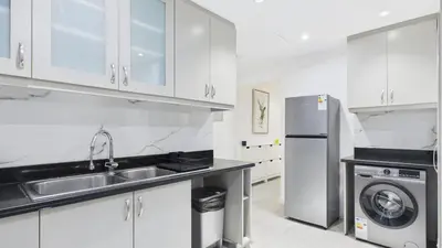 a white kitchen with a sink and a refrigerator at Spacious 2 BR with Sea and Marina View Bahar JBR in Dubai