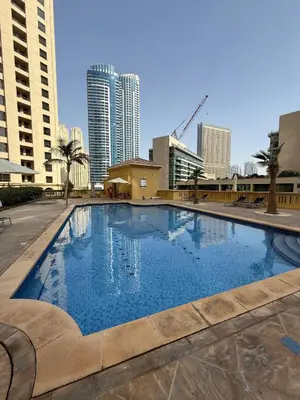 a large swimming pool in a city with tall buildings at Spacious 2 BR with Sea and Marina View Bahar JBR in Dubai
