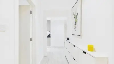 a hallway with white walls and white floors and a mirror at Spacious 2 BR with Sea and Marina View Bahar JBR in Dubai
