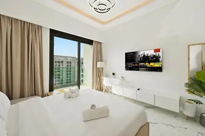 a white bedroom with a bed and a large window at Estudio Amira en Dubai by beBalmy in Dubai