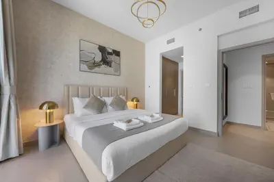 a bedroom with a large white bed with two tables at 2BR - Private Cinema - Pool - Walk to Burj Khalifa in Dubai