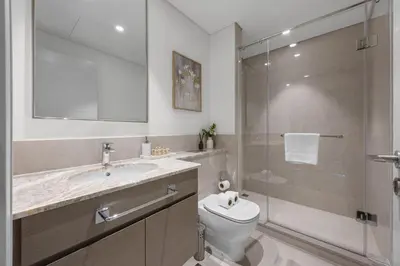a bathroom with a toilet and a glass shower at 2BR - Private Cinema - Pool - Walk to Burj Khalifa in Dubai