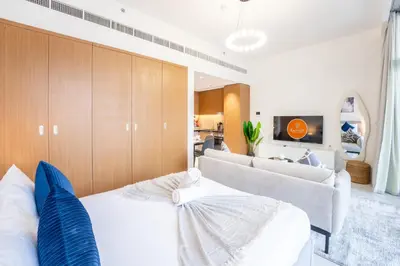 a bedroom with a white bed and a couch at EasyGo - Chic Studio Escape in Dubai Sports City in Dubai