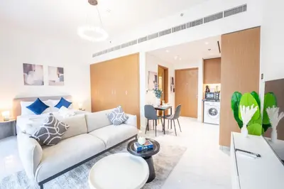 a living room with a couch and a table at EasyGo - Chic Studio Escape in Dubai Sports City in Dubai