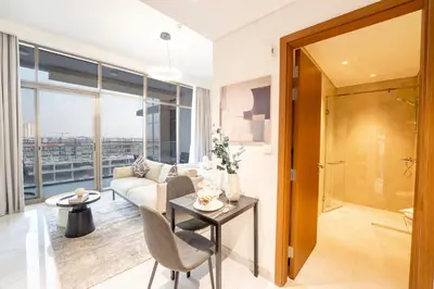 a living room with a couch and a table at EasyGo - Chic Studio Escape in Dubai Sports City in Dubai