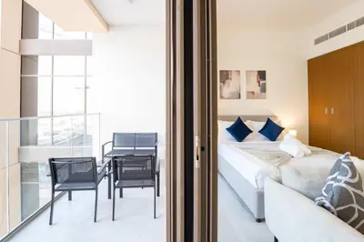 a bedroom with a bed and a table and chairs at EasyGo - Chic Studio Escape in Dubai Sports City in Dubai