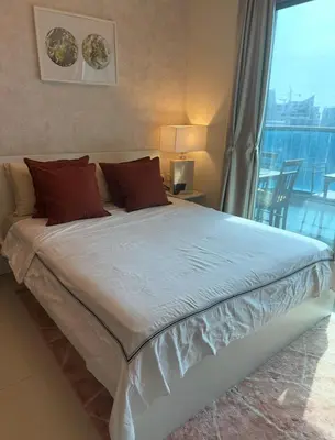 a large bed in a room with a large window at Helena - spacious studio with canal view and big Balcony in Dubai
