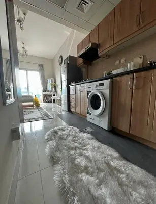 a kitchen with a washing machine and a rug at Helena - spacious studio with canal view and big Balcony in Dubai