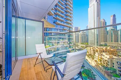 a balcony with white chairs and a view of a city at Premium 2BR at Imperial Avenue overlooking Burj Khalifa in Dubai