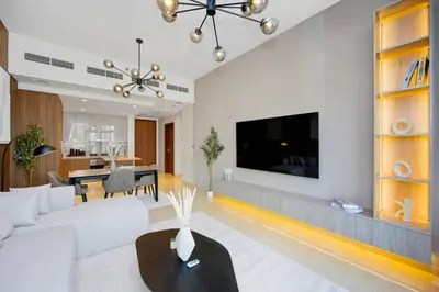 a living room with a white couch and a tv at Premium 2BR at Imperial Avenue overlooking Burj Khalifa in Dubai