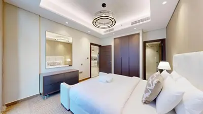 a bedroom with a white bed and a mirror at Vacationer l Modern 1 Bedroom l City Views l Prime Location in Dubai