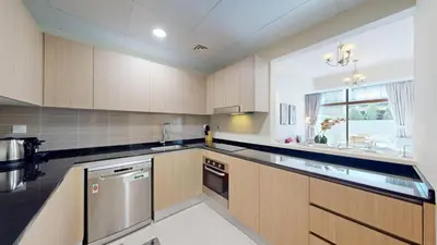 a large kitchen with wooden cabinets and a window at Locations l Spectacular 4 Bed Villa l Garden l Wadi Al Safa in Dubai