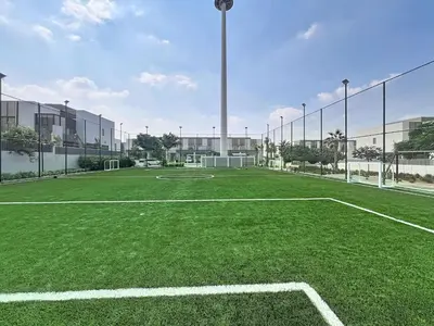 an empty soccer field in front of a building at Locations l Spectacular 4 Bed Villa l Garden l Wadi Al Safa in Dubai