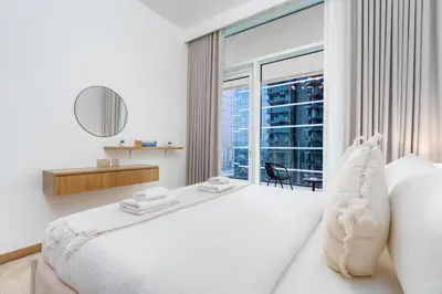 a bedroom with a white bed and a large window at Vacay Lettings - Missoni Luxury 2 BR Urban Oasis Dubai Canal View in Dubai