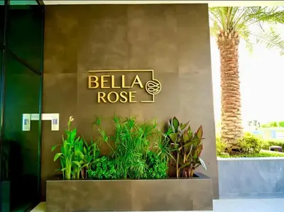 a sign for a bellia rose office with a palm tree at Stunning New Studio - Near Dubai Hills Mall in Dubai