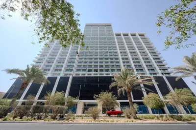 a tall building with a red car in front of it at Elegant 1BR Unit with Premium Finish in Dubai