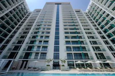 an image of a large apartment building with a swimming pool at Elegant 1BR Unit with Premium Finish in Dubai