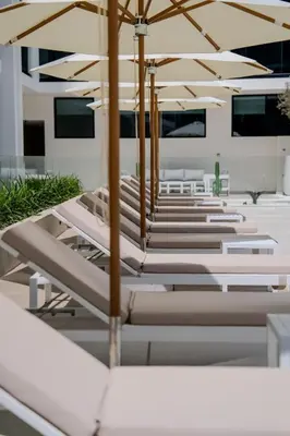 a row of benches with umbrellas on a building at Elegant 1BR Unit with Premium Finish in Dubai