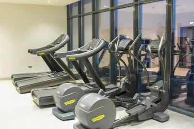a row of tread machines in a gym at Stunning - Cozy Studio - Azizi Riviera in Dubai
