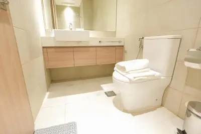 a white bathroom with a toilet and a sink at Stunning - Cozy Studio - Azizi Riviera in Dubai