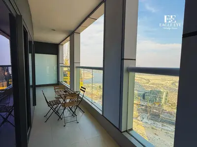 a balcony with tables and chairs in a building at EagleEye Paramount Tower D 1BR Sleeps 4 in Dubai