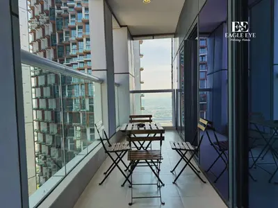 a balcony with a table and chairs and windows at EagleEye Paramount Tower D 1BR Sleeps 4 in Dubai