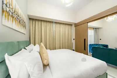 a bedroom with a large white bed in a room at ALiving Elegant 1BR I Golf Gate, DAMAC Hills in Dubai