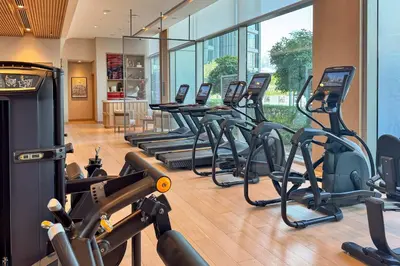 a gym with rows of treadmills and elliptical machines at PVH - Burj Khalifa View 2BR - Vida Dubai Mall in Dubai