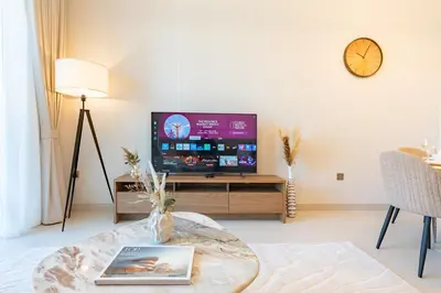 a living room with a tv and a coffee table at PVH - Burj Khalifa View 2BR - Vida Dubai Mall in Dubai