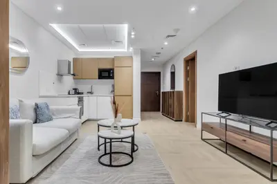 a living room with a couch and a tv at Elegant 1BR with Balcony in Dubai Marina by EE Holiday Homes in Dubai