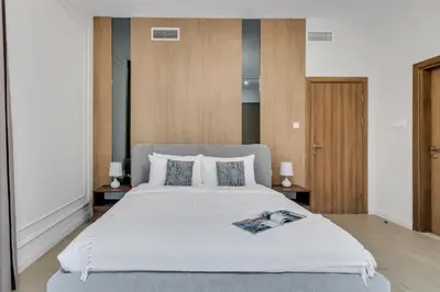 a bedroom with a large white bed with two lamps at Elegant 1BR with Balcony in Dubai Marina by EE Holiday Homes in Dubai