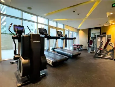 a gym with several treadmills and elliptical machines at Silk Valley - Luxury DAMAC Studio near Dubai Mall & Burj Khalifa in Dubai
