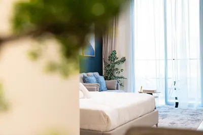 a bedroom with a bed and a couch in front of a window at HAVN - Modern Studio in Dusk, Al Barsha in Dubai