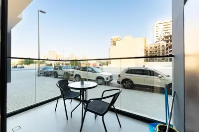 a balcony with a table and chairs and a view of a parking lot at HAVN - Modern Studio in Dusk, Al Barsha in Dubai