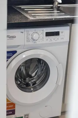 a white washing machine with a sink on top of it at Deluxe Nine Tower Suites By Hostiva - Downtown in Dubai