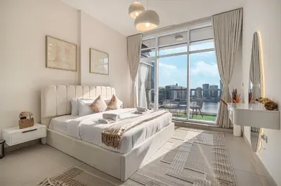 a white bedroom with a bed and a large window at Deluxe Nine Tower Suites By Hostiva - Downtown in Dubai