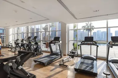 a gym with a lot of treadmills and elliptical machines at Deluxe Nine Tower Suites By Hostiva - Downtown in Dubai