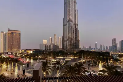 a city skyline with tall buildings and palm trees at Private Room in Luxurious 3BR Apt in Downtown, Direct Access to Dubai Mall and Metro in Dubai