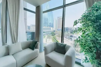 a living room with two chairs and a large window at Private Room in Luxurious 3BR Apt in Downtown, Direct Access to Dubai Mall and Metro in Dubai