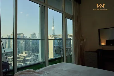 a bedroom with a large window with a view of a city at Wake Up to the Burj Khalifa Stunning view 1BR Stay in Dubai