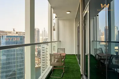 a balcony with chairs and tables on a building at Wake Up to the Burj Khalifa Stunning view 1BR Stay in Dubai