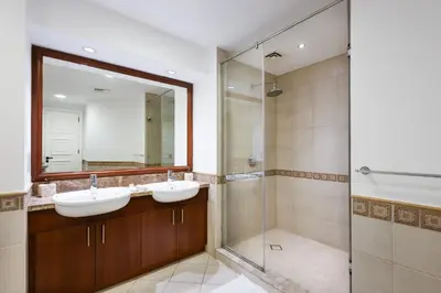 a bathroom with two sinks and a glass shower at Spacious 1BR with Terrace l Near Palm Jumeirah Mall in Dubai