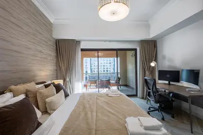 a hotel room with a large bed and a desk at Spacious 1BR with Terrace l Near Palm Jumeirah Mall in Dubai