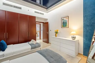 a bedroom with a bed and a dresser in it at Luxe 3 Bedroom Apartment with Maid Room, Dubai Eye and Sea View in Dubai