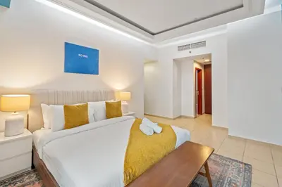 a bedroom with a white bed and a wooden table at Luxe 3 Bedroom Apartment with Maid Room, Dubai Eye and Sea View in Dubai