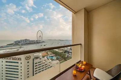 a room with a balcony with a view of the ocean at Luxe 3 Bedroom Apartment with Maid Room, Dubai Eye and Sea View in Dubai