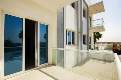 a balcony with glass doors and a view of the ocean at Dezire Premium Fully Furnished 1 BHK Apartment in Dubai