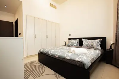 a bedroom with a large bed with white cabinets at Dezire Premium Fully Furnished 1 BHK Apartment in Dubai