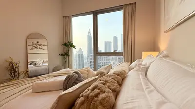 a bedroom with a large bed with a large window at UNIQUE - BURJ KHALIFA & FOUNTAIN ViEW-4 BR in Dubai