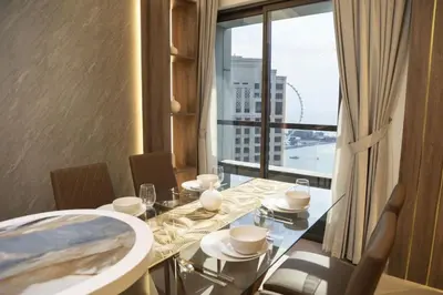 a dining room with a table and a large window at The Royale Vista Burj Khalifa View Residence in Dubai